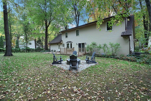 back of house with a yard, a patio area, and an outdoor fire pit