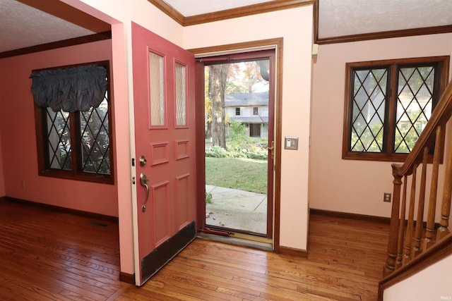 foyer featuring crown molding, hardwood / wood-style floors, and a textured ceiling