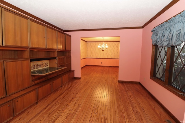 living room with ornamental molding, a notable chandelier, and hardwood / wood-style flooring