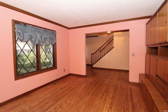 unfurnished room featuring hardwood / wood-style floors and crown molding