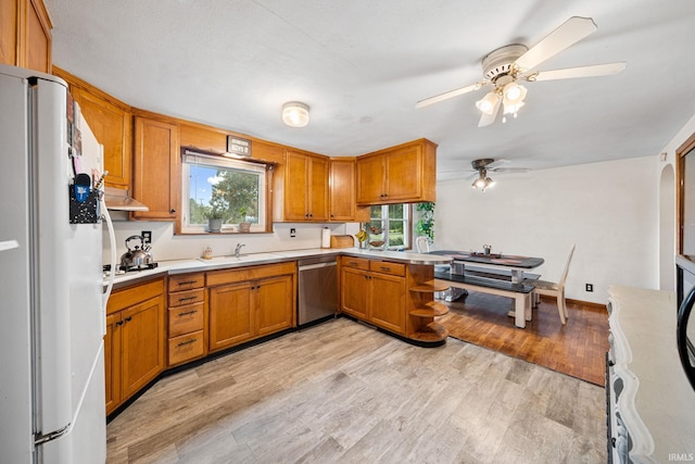 kitchen featuring sink, appliances with stainless steel finishes, light wood-type flooring, and ceiling fan