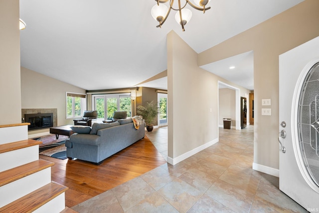 living room featuring lofted ceiling, a notable chandelier, and light wood-type flooring