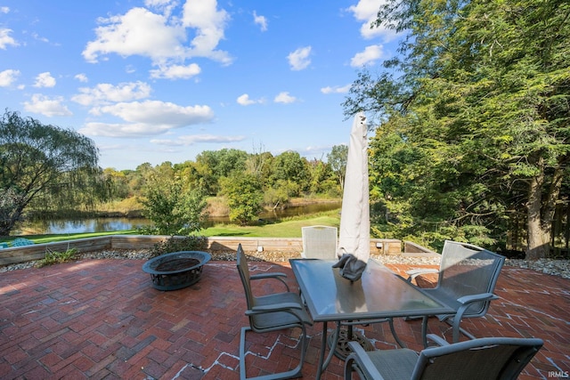 view of patio / terrace with a fire pit and a water view