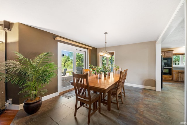 dining space featuring dark tile patterned flooring