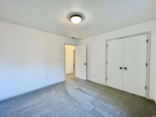 unfurnished bedroom featuring baseboards, visible vents, a closet, and carpet