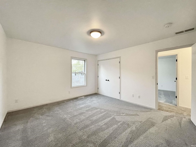 unfurnished bedroom with visible vents, carpet, and baseboards