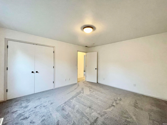 unfurnished bedroom with carpet floors and a closet