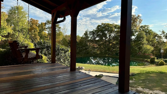 wooden deck featuring a water view and a lawn