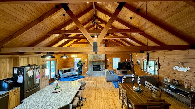 interior space featuring black fridge, wooden ceiling, light wood-type flooring, wood walls, and pendant lighting