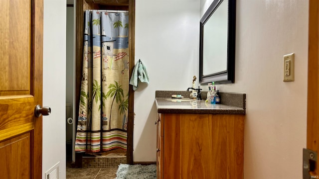 bathroom featuring vanity, walk in shower, and tile patterned flooring