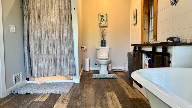 bathroom with hardwood / wood-style flooring and toilet