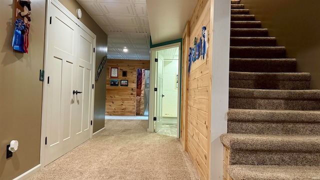 hallway with carpet floors and wooden walls