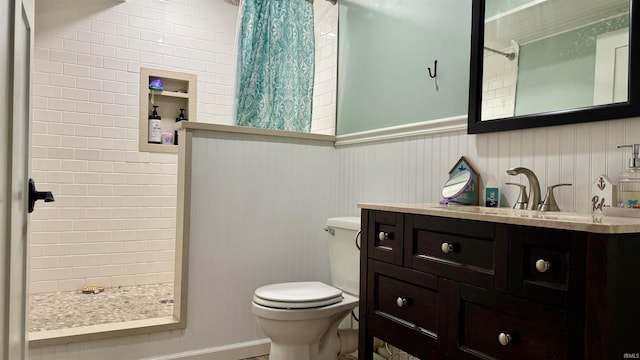 bathroom featuring vanity, tiled shower, and toilet