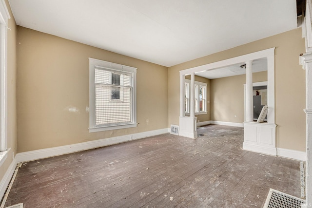 empty room featuring a healthy amount of sunlight and dark hardwood / wood-style floors