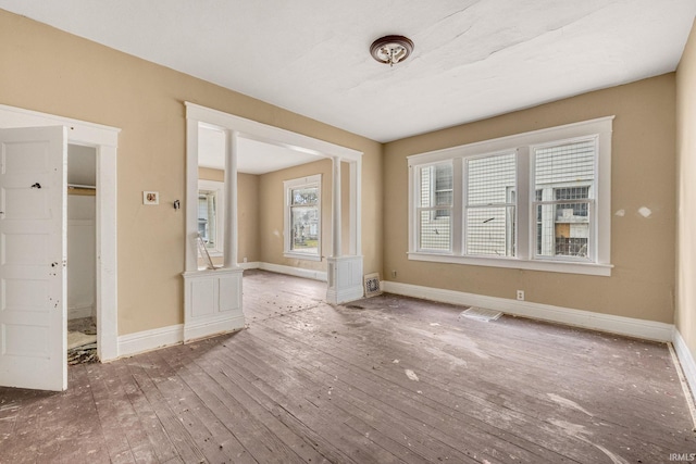 interior space featuring ornate columns and hardwood / wood-style flooring