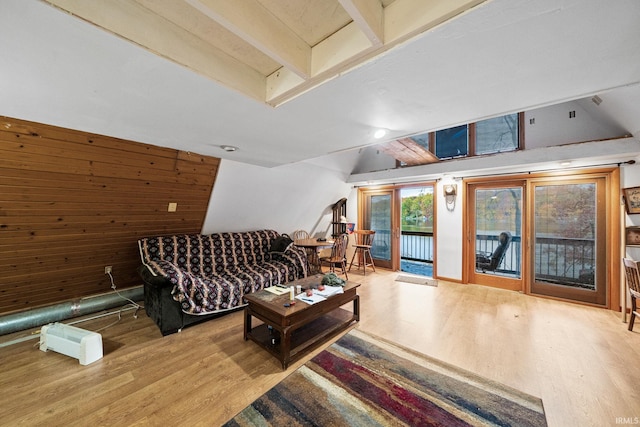 living room with beam ceiling, hardwood / wood-style flooring, and wood walls