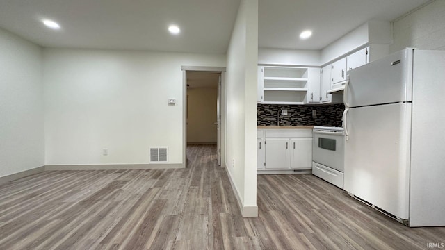 kitchen featuring white appliances, white cabinetry, and light wood-type flooring