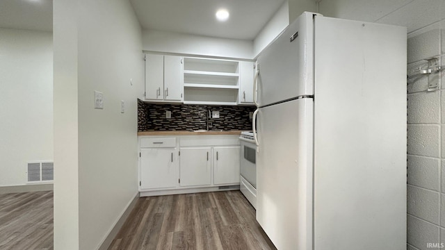 kitchen with decorative backsplash, light hardwood / wood-style floors, sink, white cabinetry, and white appliances