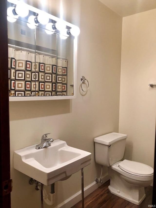 bathroom with toilet and hardwood / wood-style flooring