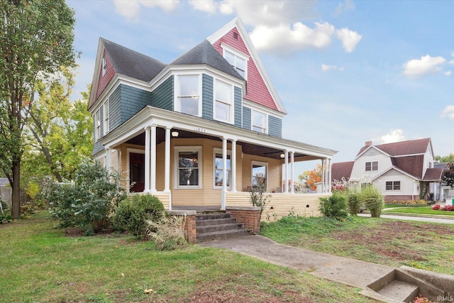 victorian-style house with a front yard and a porch