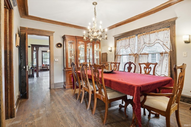 dining space featuring crown molding, dark hardwood / wood-style flooring, and a chandelier