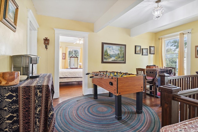 playroom with beam ceiling, ceiling fan, and dark hardwood / wood-style flooring