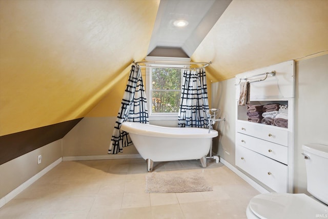 bathroom with toilet, lofted ceiling, a washtub, and tile patterned flooring