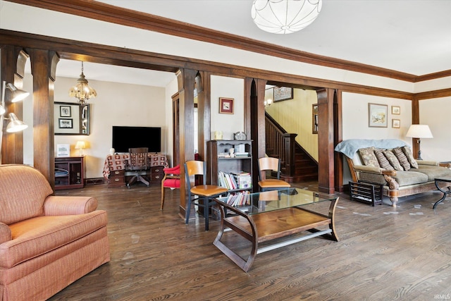 living room with dark wood-type flooring, crown molding, and a chandelier