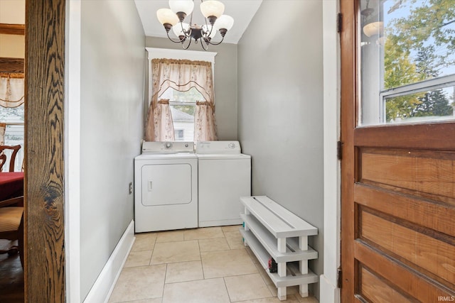 laundry room featuring a notable chandelier, light tile patterned floors, and washing machine and clothes dryer