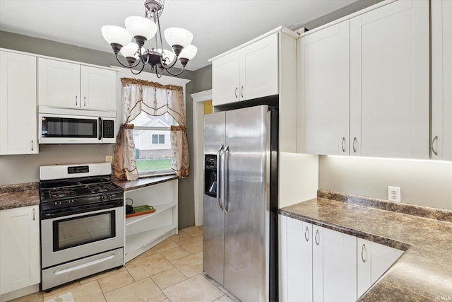 kitchen with white cabinetry, appliances with stainless steel finishes, an inviting chandelier, and pendant lighting