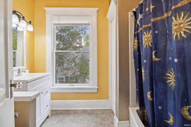 bathroom with vanity, shower / bath combination with curtain, and plenty of natural light