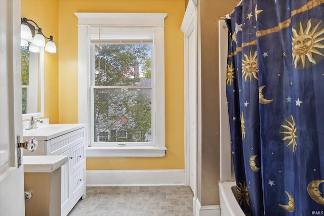 1025 W Lincolnway, Mishawaka, IN 46545 - bathroom featuring vanity, baseboards, a shower with shower curtain, and a healthy amount of sunlight