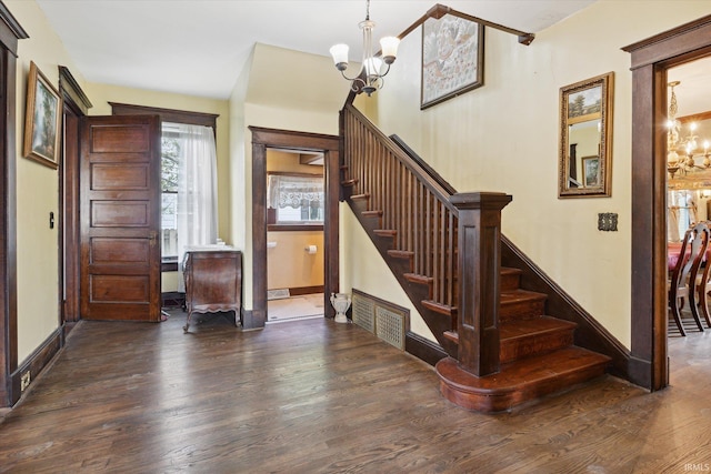 staircase with a chandelier and wood-type flooring