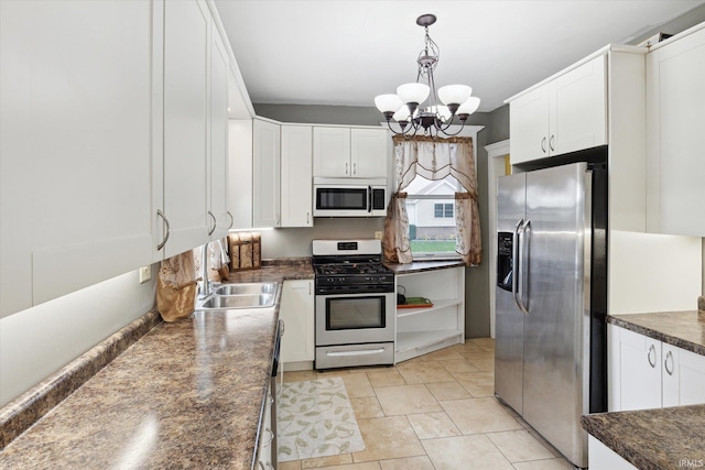 kitchen featuring white cabinets, stainless steel appliances, sink, and decorative light fixtures