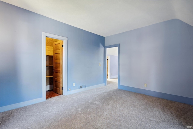 unfurnished room with lofted ceiling and carpet