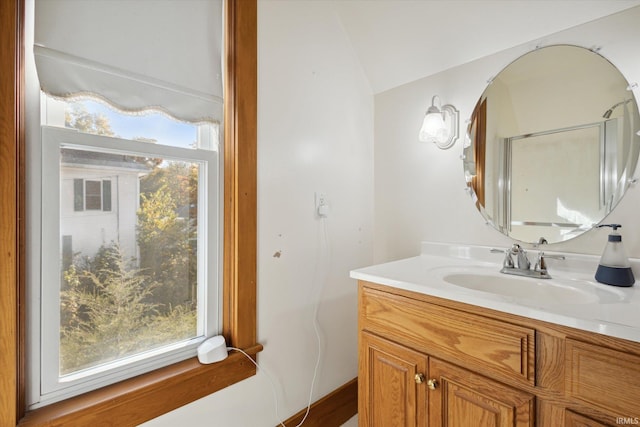 bathroom with vanity and lofted ceiling