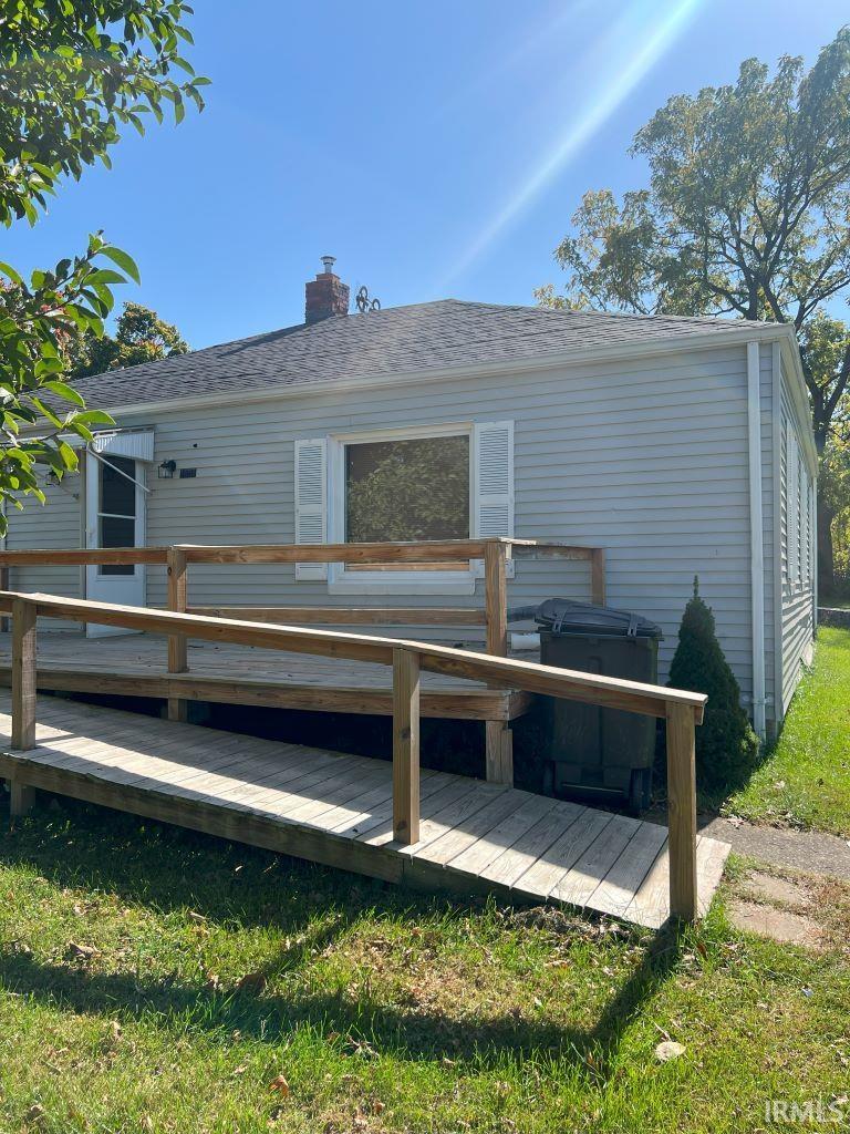 rear view of house with a deck and a lawn