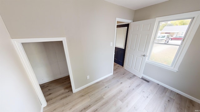 unfurnished bedroom featuring a closet and light hardwood / wood-style flooring