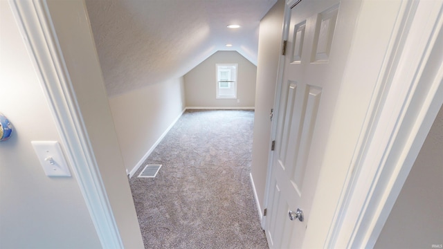 bonus room with vaulted ceiling, light carpet, and a textured ceiling