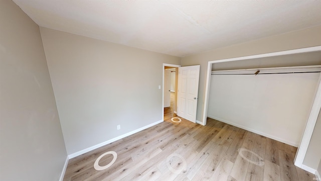 unfurnished bedroom with light hardwood / wood-style flooring and a closet