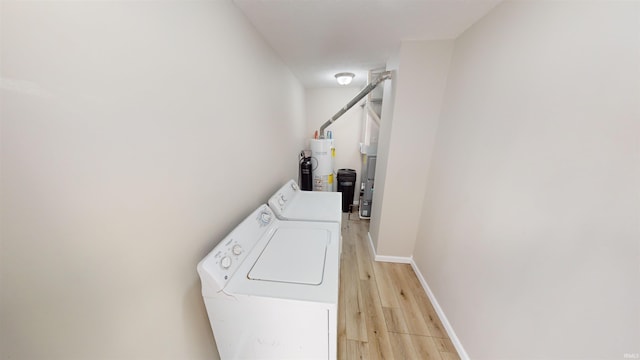 washroom featuring independent washer and dryer, water heater, and light hardwood / wood-style floors