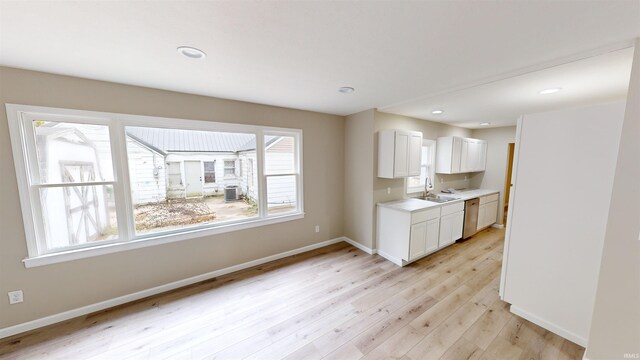 kitchen with sink, light hardwood / wood-style flooring, and white cabinets