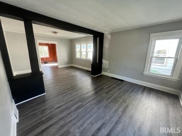 unfurnished room with dark hardwood / wood-style floors and beamed ceiling