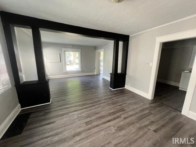 unfurnished living room featuring crown molding and dark hardwood / wood-style floors