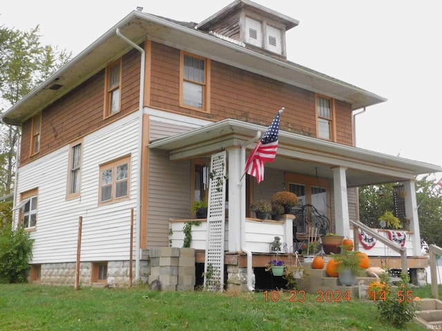 exterior space featuring covered porch and a lawn