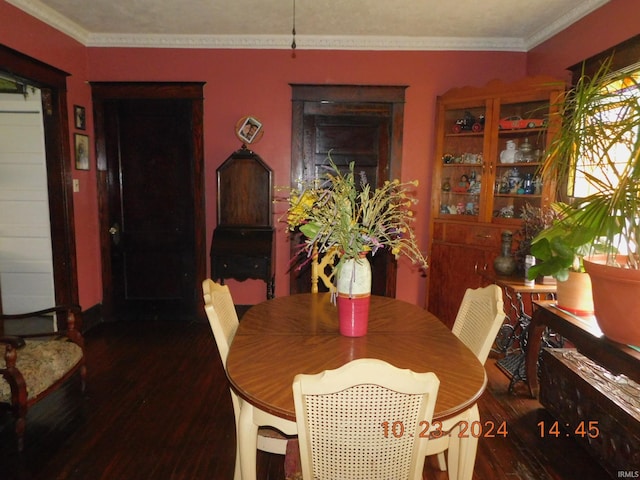 dining room featuring dark wood-type flooring and crown molding