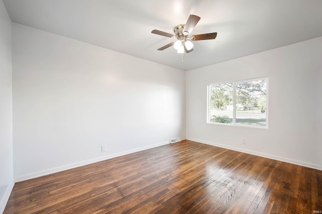 spare room with dark wood-type flooring and ceiling fan