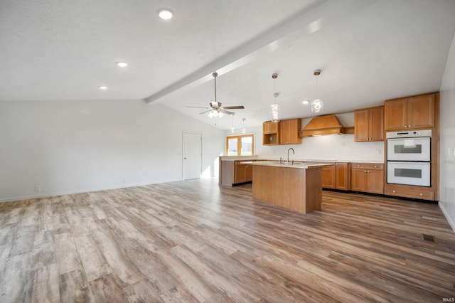 kitchen featuring vaulted ceiling with beams, custom range hood, white double oven, and wood-type flooring