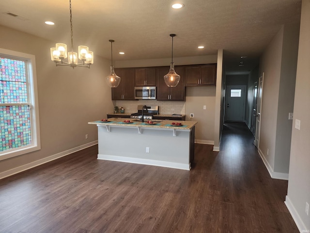 3088 Ashdon Dr, Newburgh, IN 47630 - kitchen featuring dark brown cabinets, dark wood finished floors, an inviting chandelier, backsplash, and appliances with stainless steel finishes