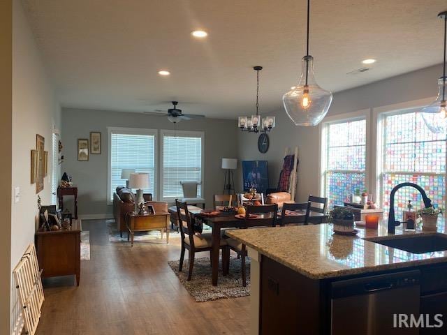 kitchen with dishwasher, hardwood / wood-style flooring, sink, decorative light fixtures, and ceiling fan with notable chandelier